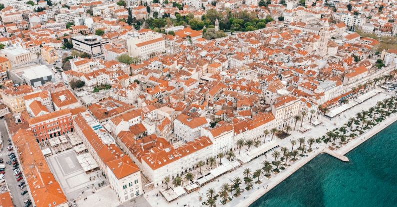 Split Travel Costs - Coastal town embankment with red roofed buildings