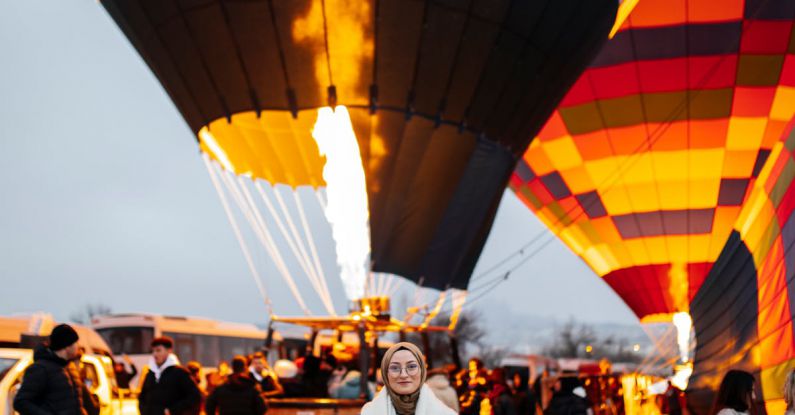 Cheapest Flights - A woman standing in front of a hot air balloon