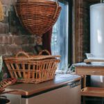 Private Rooms Vs. Dorms - Interior of kitchen with brick wall decorated with wicker baskets